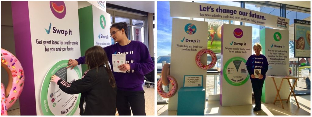 Food Standard Scotland display stands at event, woman showing information on stand to child